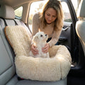 Pet mom gently placing white fluffy dog into the plush bolster walls of the car mounted dog bed