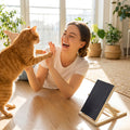 Happy woman laughing as her cat gives a paw high-five with CradlePetss Scratching Board visible - smooth nails zero fear